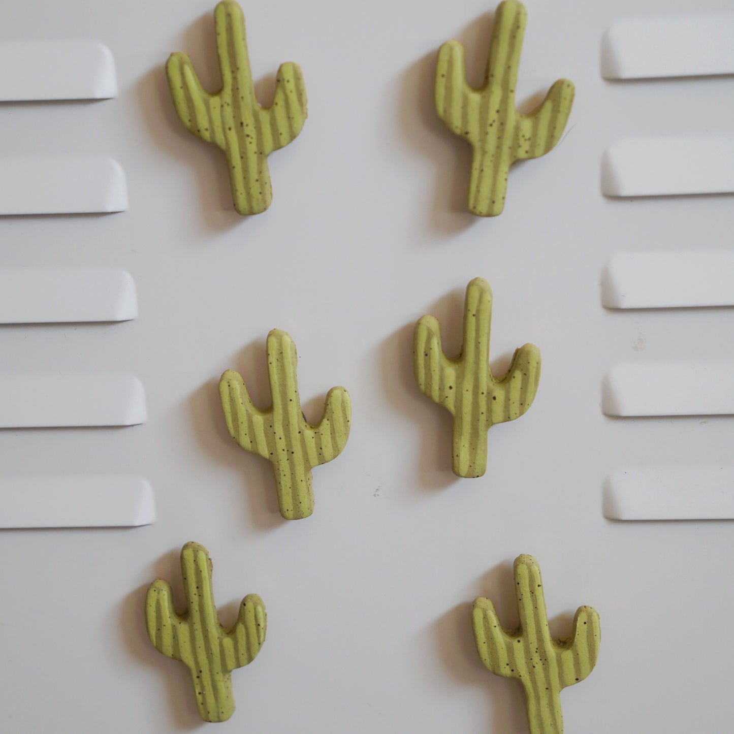 Five green cactus-shaped objects on a white background