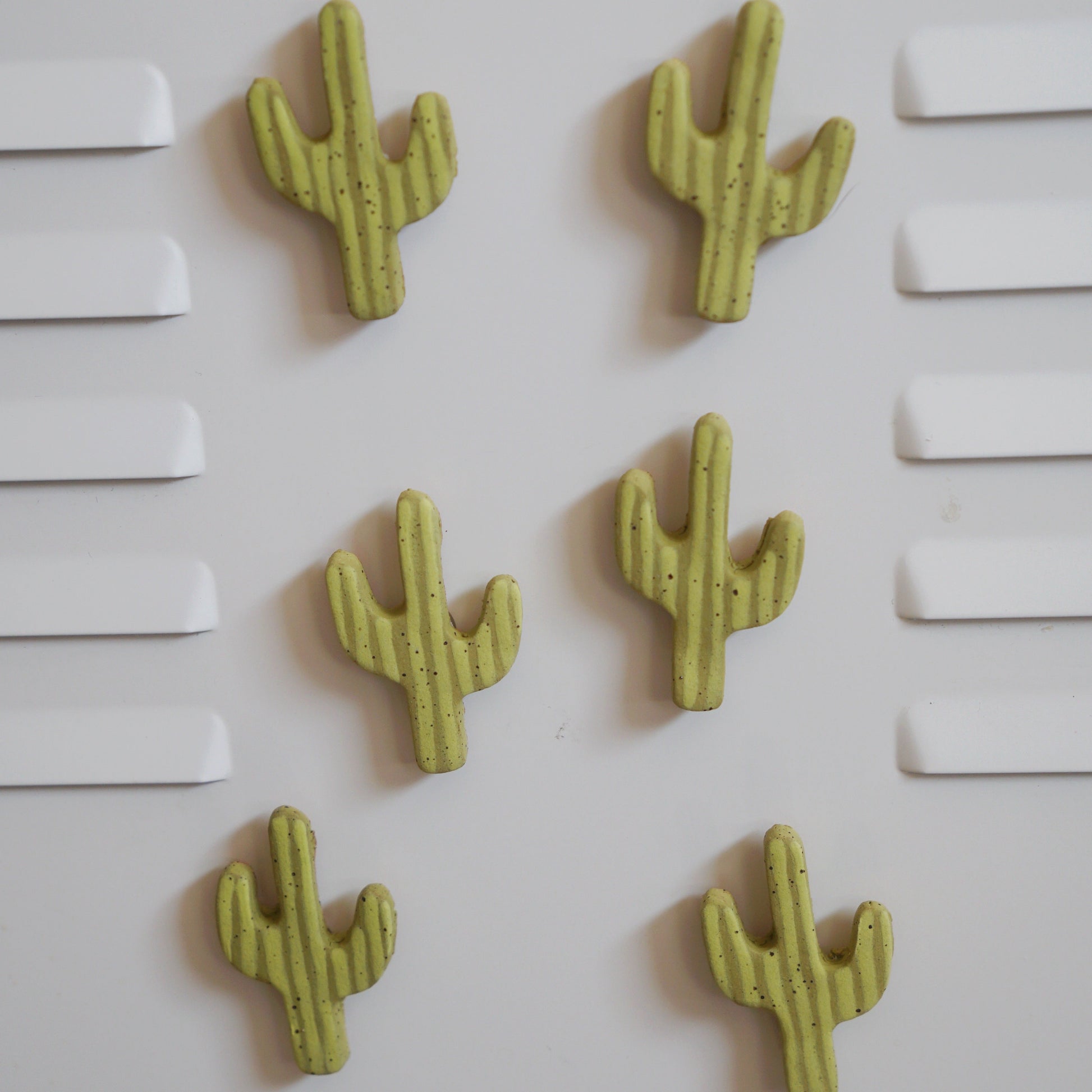 Five green cactus-shaped objects on a white background