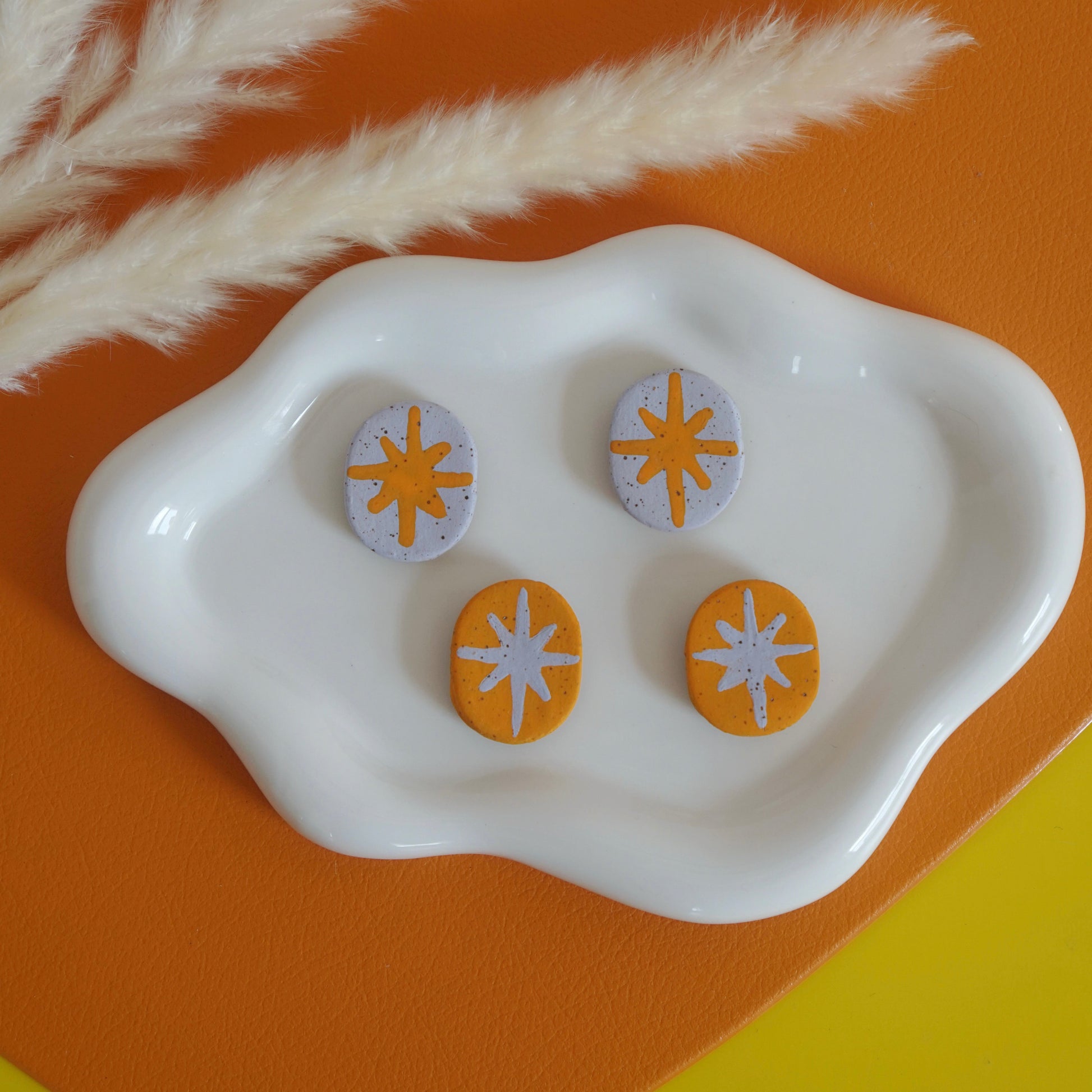 Set of magnets with retro star design on a white dish against an orange and yellow background
